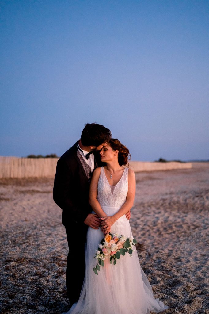 séance photos de couple de mariés en bord de mer au coucher du soleil