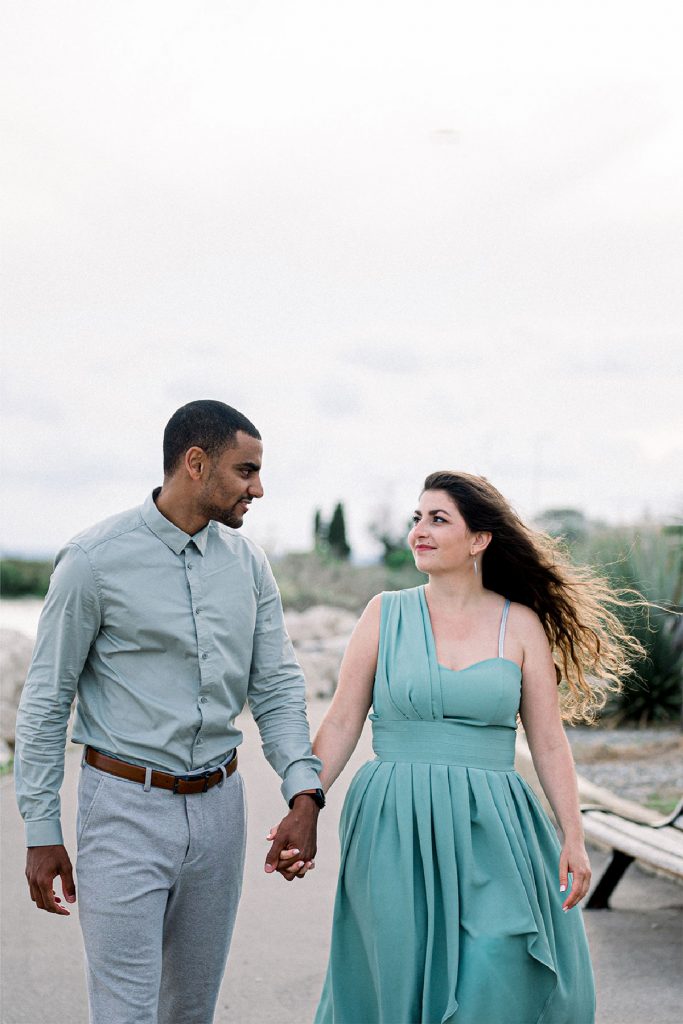 couple qui marche main dans la main en se regardant