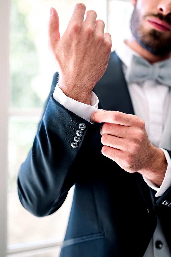 marié qui boutonne la manche de son costume pendant ses préparatifs au Mas de la Rose, lieu de réception de mariage en Provence dans le sud de la France