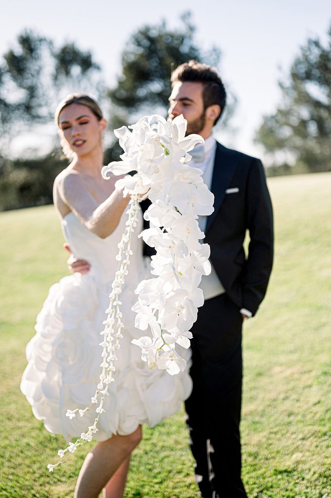 bouquet de fleurs blanches en cascade tenu par la mariée avec son mari