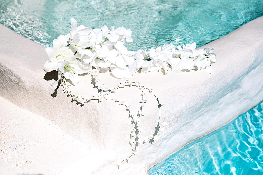 bouquet de la mariée composé de lys blancs et de jasmin. Le bouquet est posé au bord de la piscine du Mas de la Rose, lieu de réception de mariage de luxe en Provence