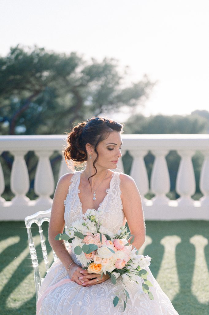 mariée tenant son bouquet sur la terrasse du Castel Bay