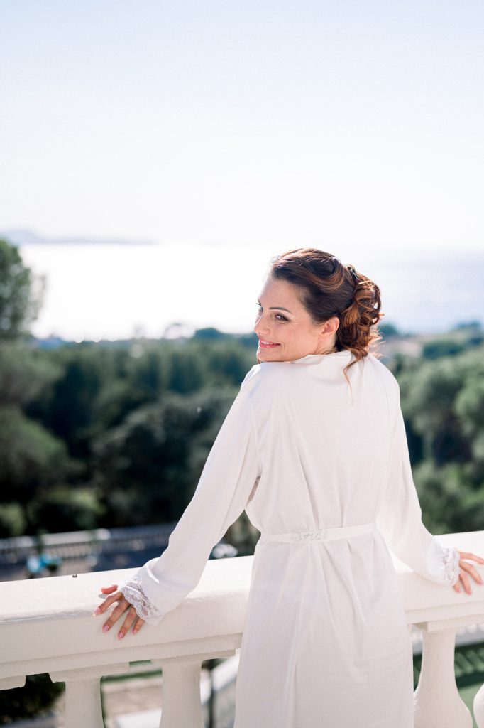 mariée de dos au balcon du Castel Bay avec vue sur la mer